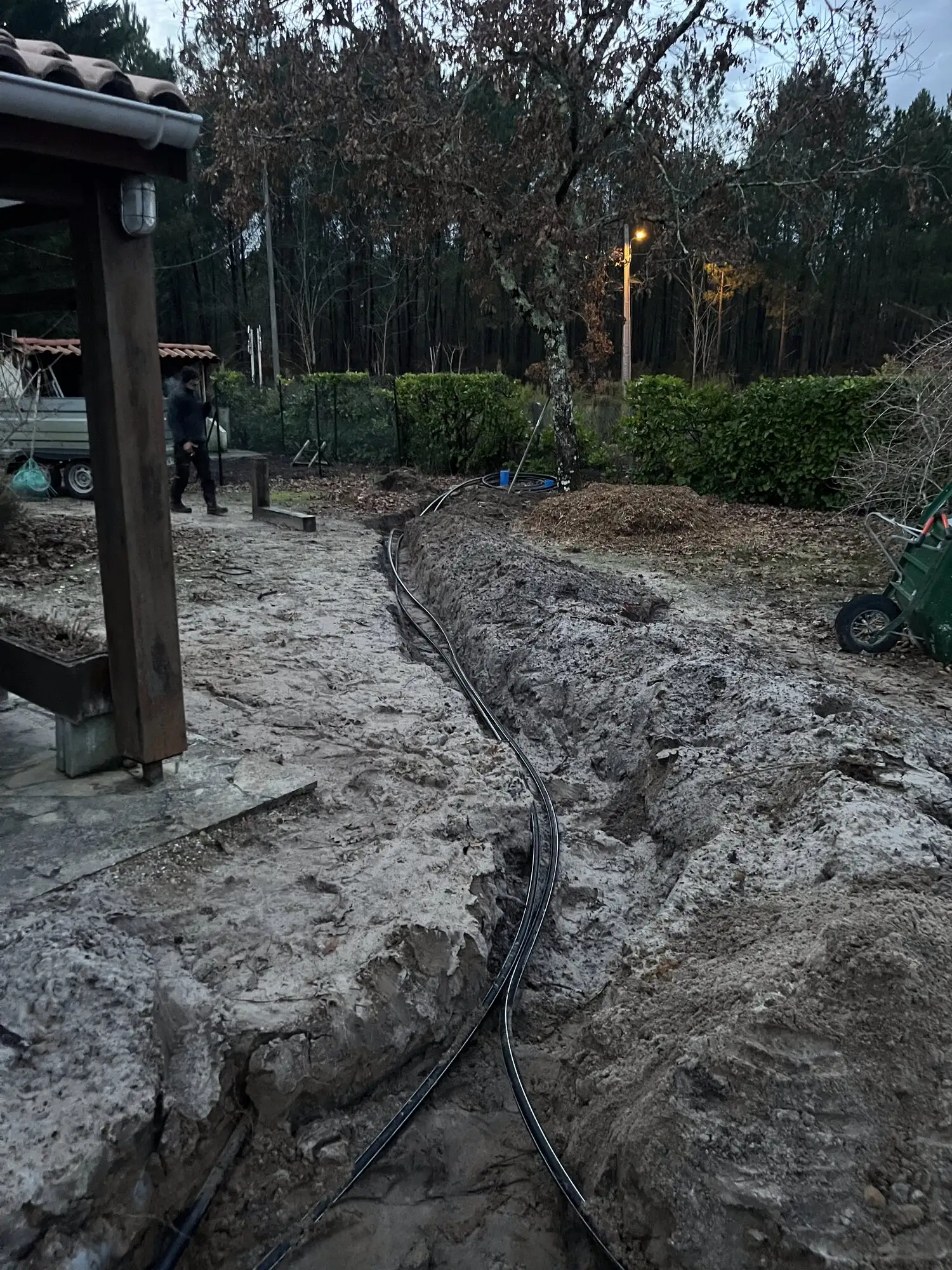 Réseau d'arrosage posé le long d'une terrasse couverte, en fin de journée