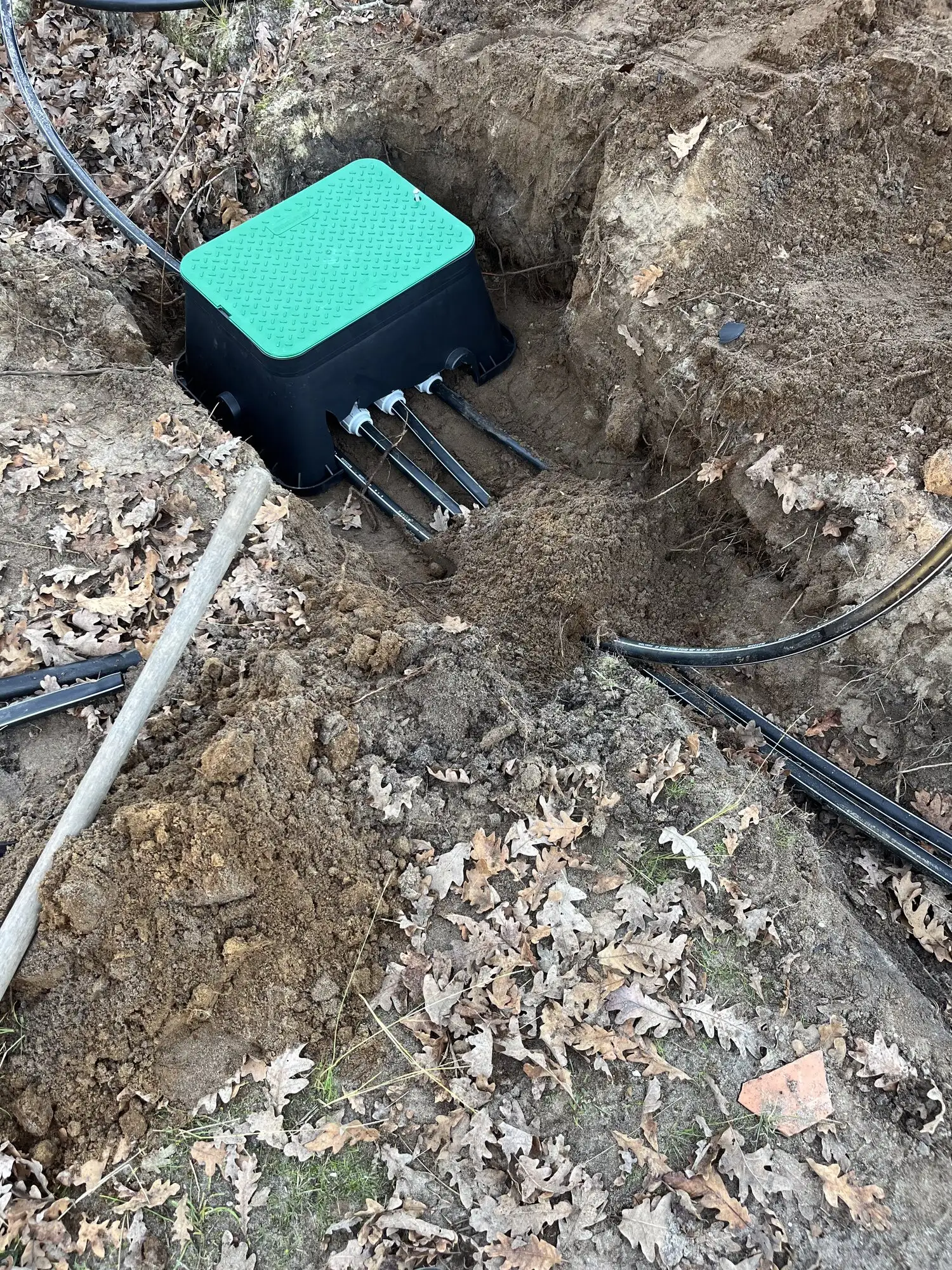 Coffret d'électrovannes installé dans son regard, raccordé aux différentes zones d'arrosage