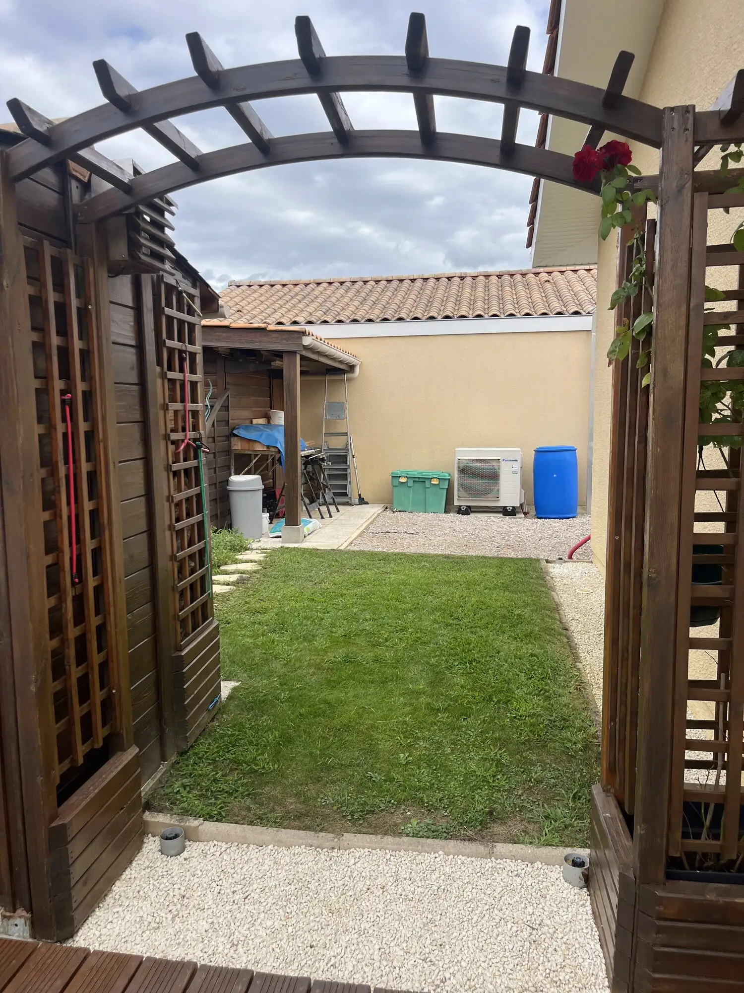 Pelouse tondue vue depuis une pergola en bois