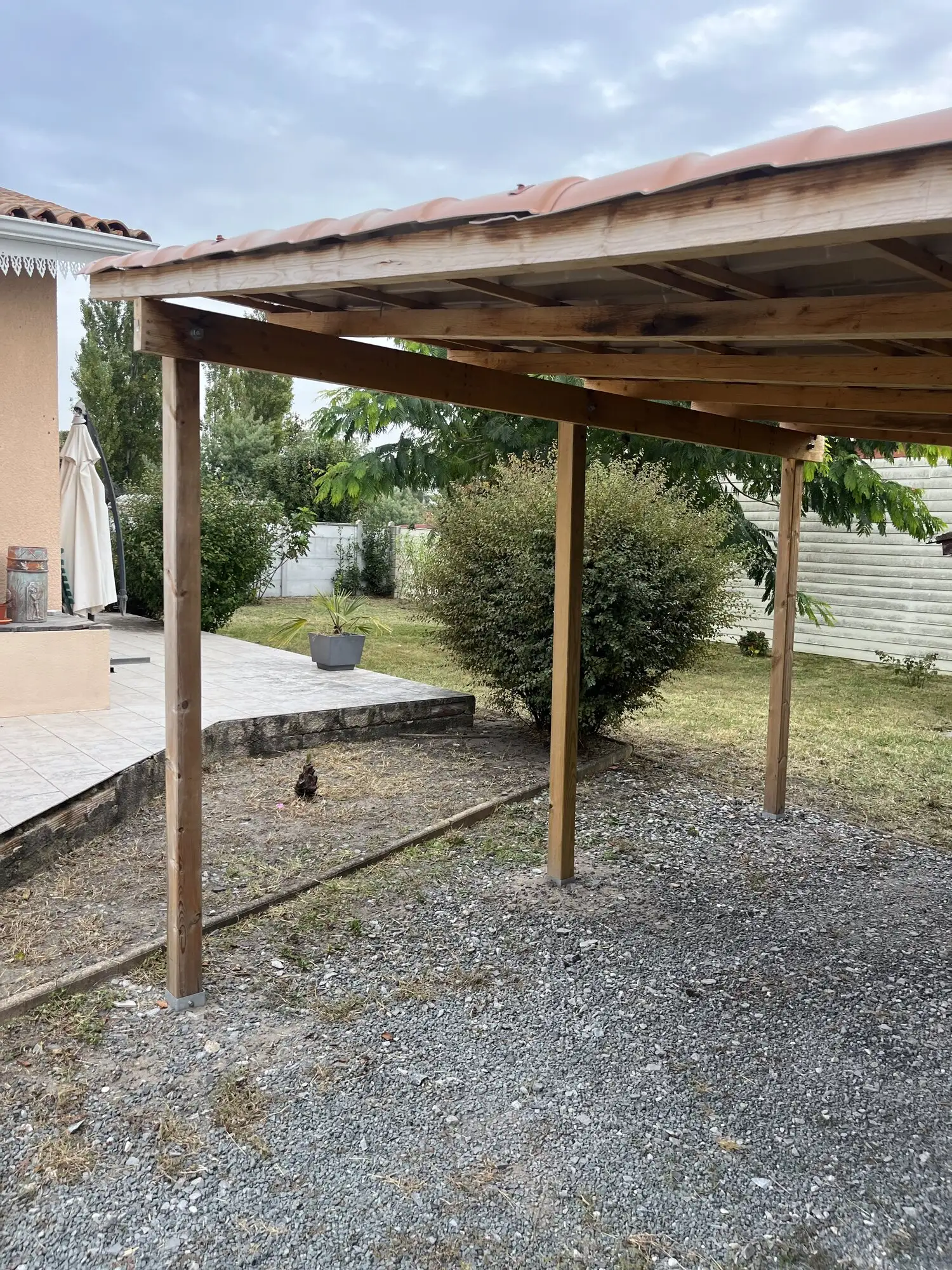 Espace sous la pergola nettoyé, pelouse tondue à l'arrière